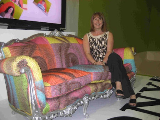 The finished sofa, upholstered in a fabric printed with faces